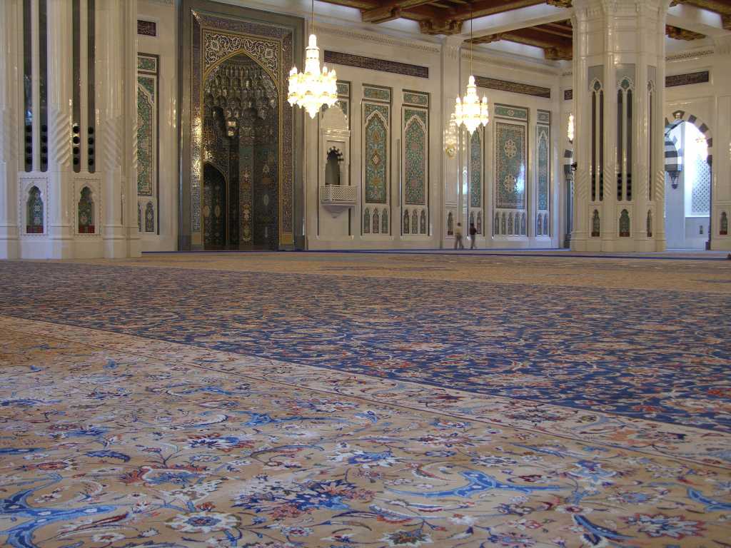 Muscat 04 Grand Mosque 06 Large Persian Carpet The main prayer hall has the largest carpet in the world, a 70m x 60m Persian carpet that took 600 women four years to weave. On the back wall is the mihrab, a niche in the wall facing Mecca. To the right of the mihrab is the minbar, a pulpit chair dating from the Prophet Mohammeds time. The `imam', the one who leads the prayer, delivers the `khutba', the Friday sermon, which can deal with religious, social and political subjects.